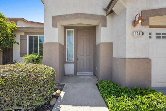 12415 Childress St, Bakersfield, CA 93312 - doorway to property with stucco siding and a garage