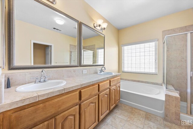 12415 Childress St, Bakersfield, CA 93312 - bathroom with a stall shower, a garden tub, double vanity, and tile patterned flooring