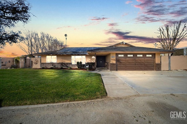 view of front of home with a yard, a garage, and solar panels