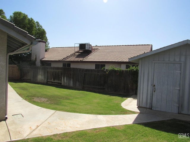 view of yard featuring central air condition unit and a shed