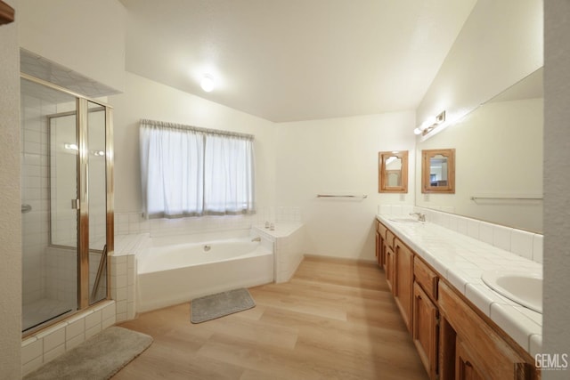 bathroom with hardwood / wood-style floors, vanity, lofted ceiling, and shower with separate bathtub