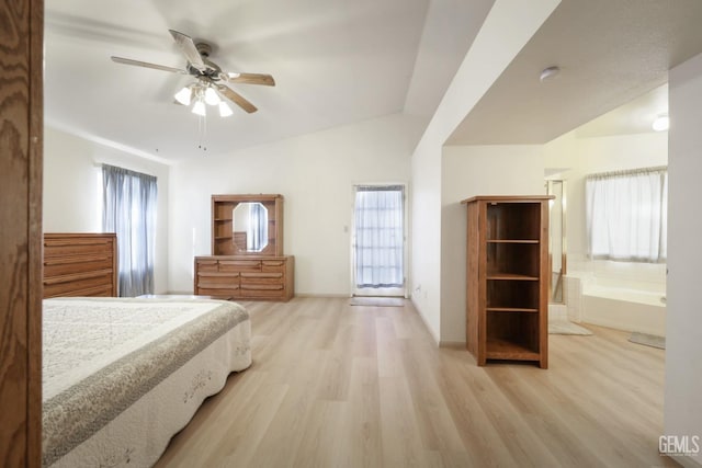 bedroom featuring ceiling fan, light hardwood / wood-style flooring, ensuite bathroom, and vaulted ceiling