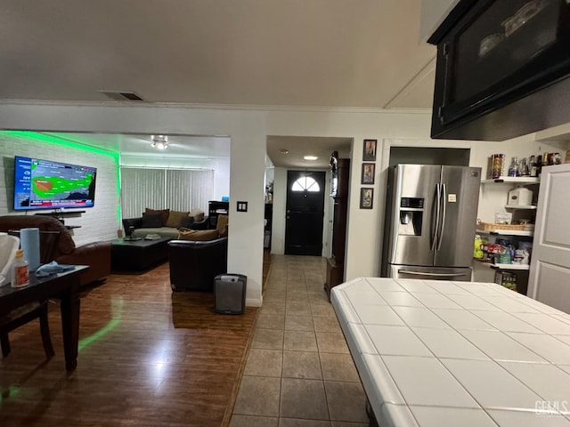 6301 Scenic Way, Bakersfield, CA 93309 - kitchen with stainless steel refrigerator with ice dispenser, tile countertops, ornamental molding, and dark tile patterned floors