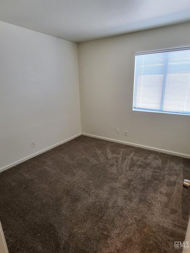 11511 Bay Meadows Ln, Bakersfield, CA 93312 - empty room featuring dark colored carpet and baseboards