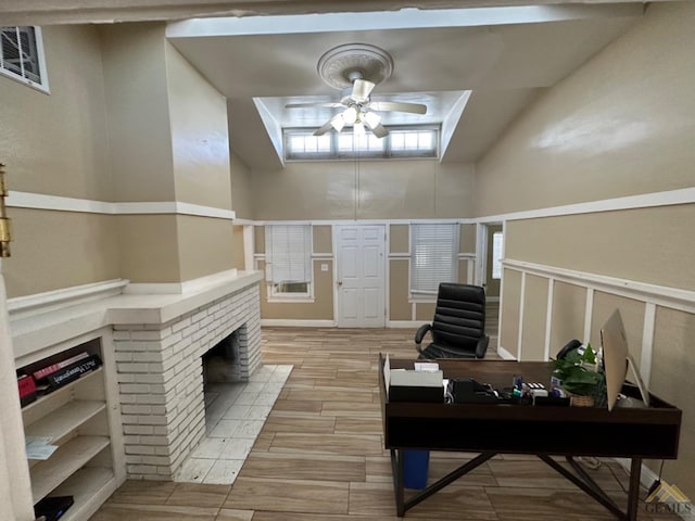 office area with wood tiled floor, visible vents, ceiling fan, and a fireplace