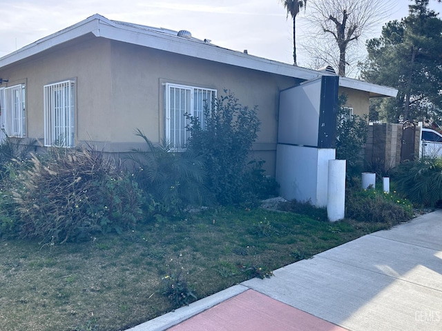 view of home's exterior featuring a lawn and stucco siding