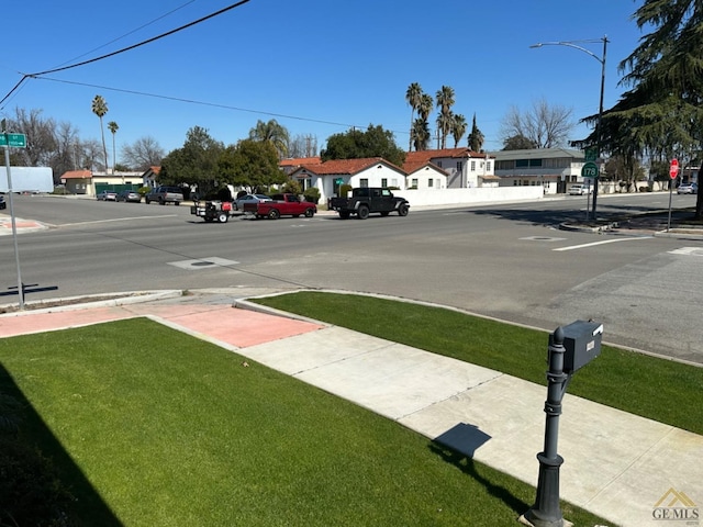 view of road featuring traffic signs, sidewalks, and street lights