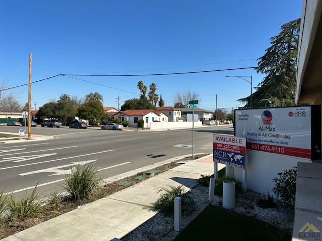 view of road with sidewalks, street lighting, and curbs