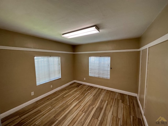 spare room with wood finished floors and baseboards