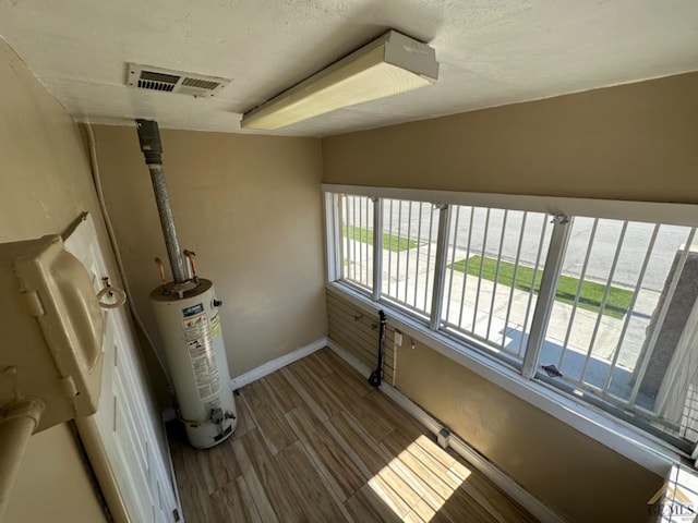 utility room featuring water heater and visible vents