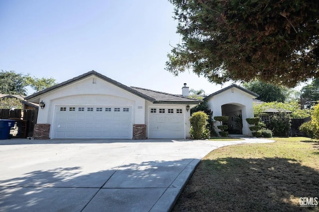 single story home featuring brick siding, a chimney, stucco siding, an attached garage, and driveway