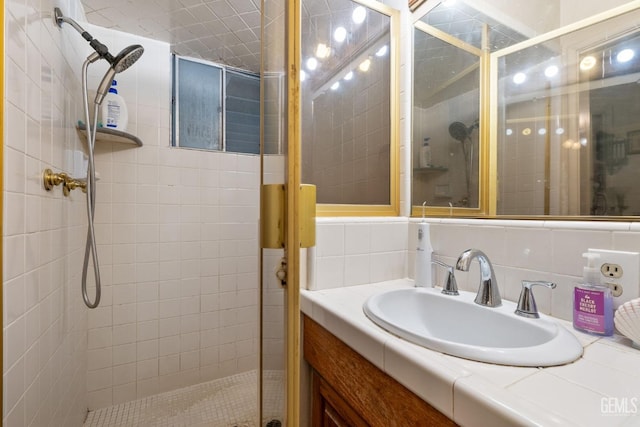 full bathroom featuring a stall shower, decorative backsplash, and vanity