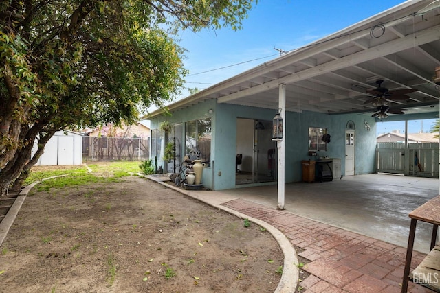 view of patio / terrace featuring ceiling fan, a carport, and fence