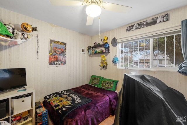 bedroom featuring wallpapered walls and a ceiling fan