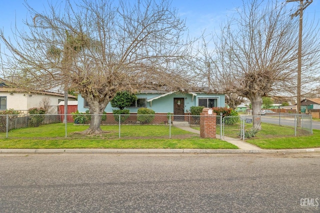 view of front facade featuring a front lawn, a fenced front yard, a gate, and stucco siding