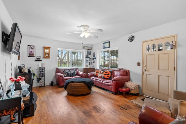 living area with light wood-type flooring and a ceiling fan