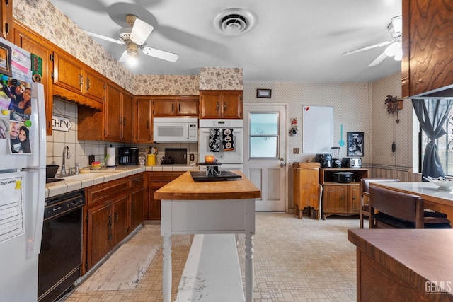 kitchen with visible vents, a ceiling fan, a sink, white appliances, and wallpapered walls