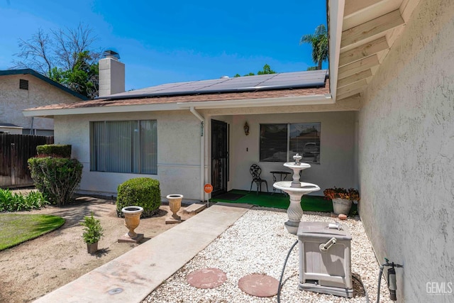 6012 Cumin Ln, Bakersfield, CA 93309 - entrance to property featuring stucco siding, roof mounted solar panels, and a chimney