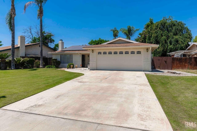 6012 Cumin Ln, Bakersfield, CA 93309 - view of front of house featuring solar panels, a garage, stucco siding, driveway, and a chimney