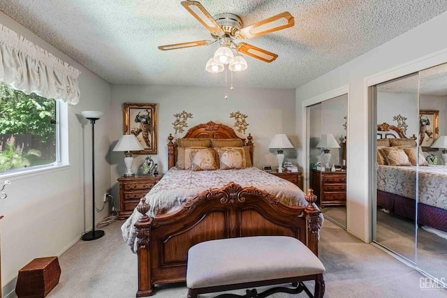 6012 Cumin Ln, Bakersfield, CA 93309 - bedroom featuring multiple closets, light carpet, a textured ceiling, and ceiling fan