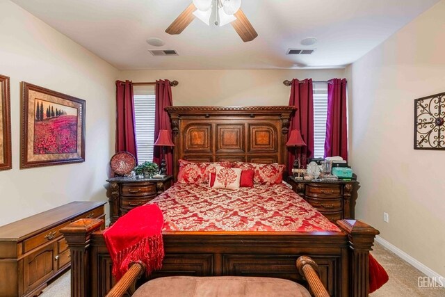 bedroom with a ceiling fan, visible vents, light carpet, and baseboards