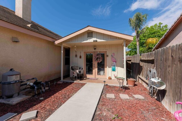 view of exterior entry with fence and french doors