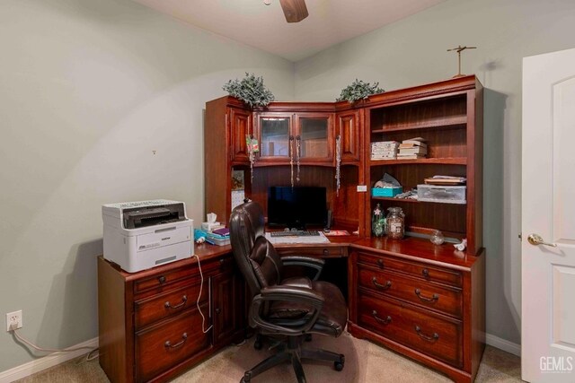 office featuring light colored carpet, a ceiling fan, and baseboards