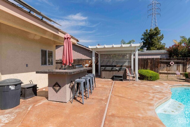 view of patio / terrace featuring a fenced in pool, a fenced backyard, a hot tub, and outdoor dry bar