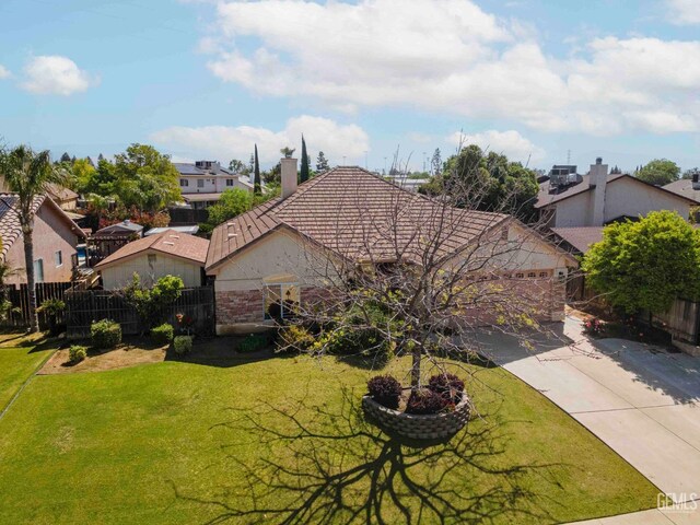 ranch-style home with fence, a front yard, a residential view, and a tile roof