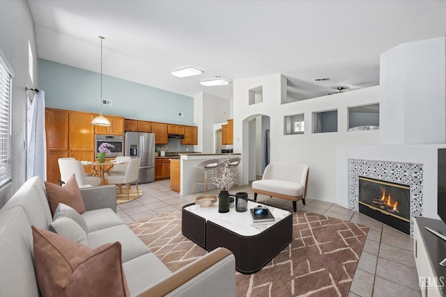 5836 S Greenhorn Mountain Ct, Bakersfield, CA 93313 - living room with high vaulted ceiling, light tile patterned flooring, and a tiled fireplace