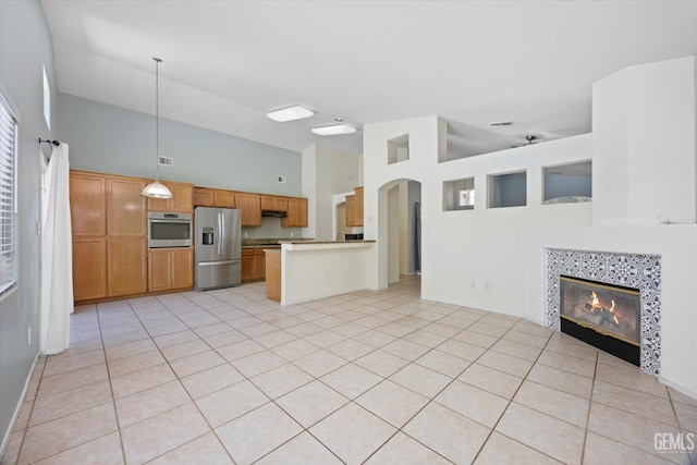 5836 S Greenhorn Mountain Ct, Bakersfield, CA 93313 - kitchen featuring appliances with stainless steel finishes, open floor plan, high vaulted ceiling, a peninsula, and a fireplace