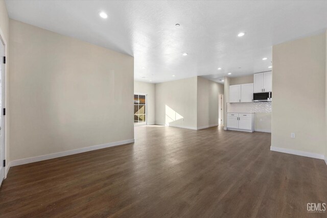 unfurnished living room with dark wood-type flooring