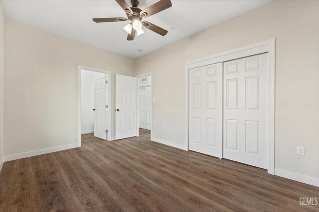 unfurnished bedroom with dark hardwood / wood-style flooring, a closet, and ceiling fan