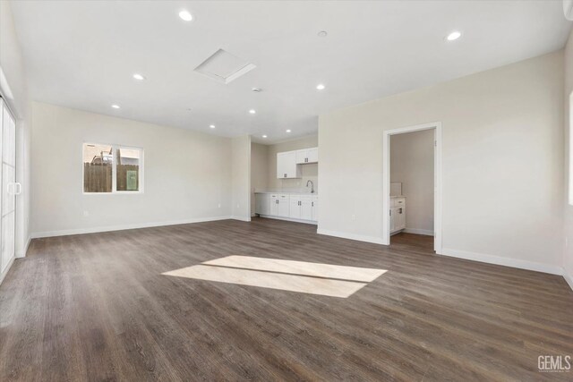 unfurnished living room with dark hardwood / wood-style flooring and sink