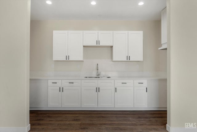 kitchen featuring dark hardwood / wood-style flooring, sink, and white cabinets