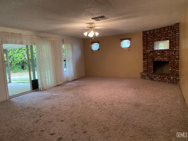 unfurnished living room featuring carpet flooring, a textured ceiling, ceiling fan, and a fireplace