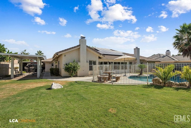 13019 Queen Palm Ct, Bakersfield, CA 93314 - back of house with a patio, stucco siding, solar panels, and a chimney
