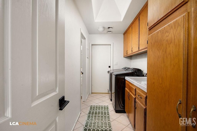 13019 Queen Palm Ct, Bakersfield, CA 93314 - laundry area featuring washing machine and clothes dryer, cabinet space, light tile patterned floors, and a skylight