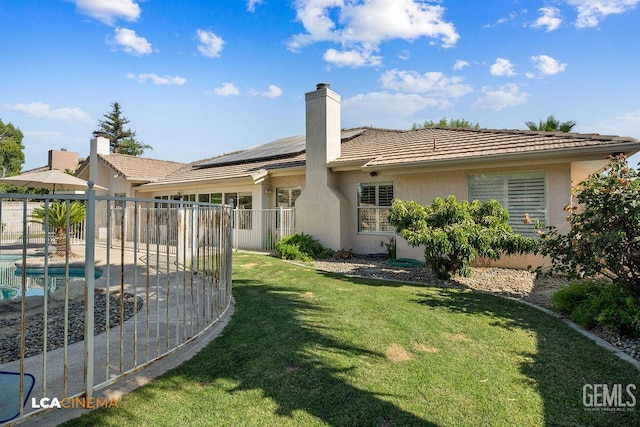 13019 Queen Palm Ct, Bakersfield, CA 93314 - rear view of property featuring roof mounted solar panels, stucco siding, a tiled roof, and a chimney