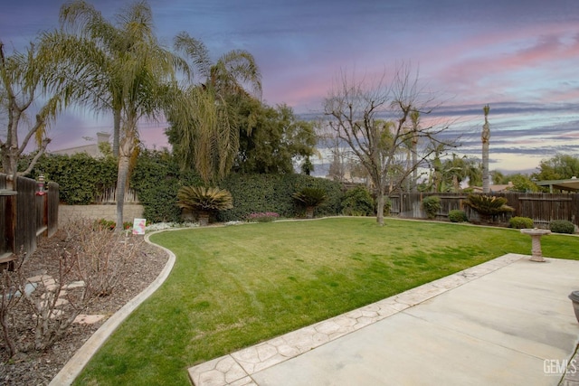 yard at dusk featuring a patio