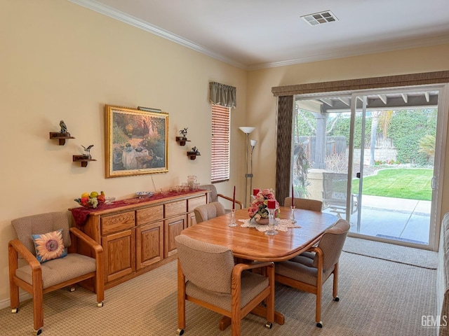 dining area with ornamental molding and light colored carpet