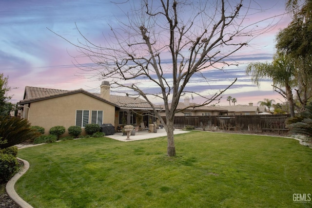 yard at dusk with a patio area