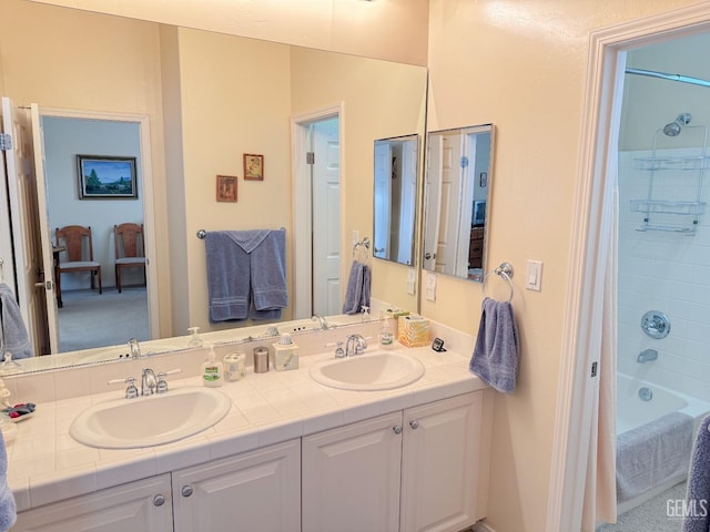 bathroom with tiled shower / bath and vanity