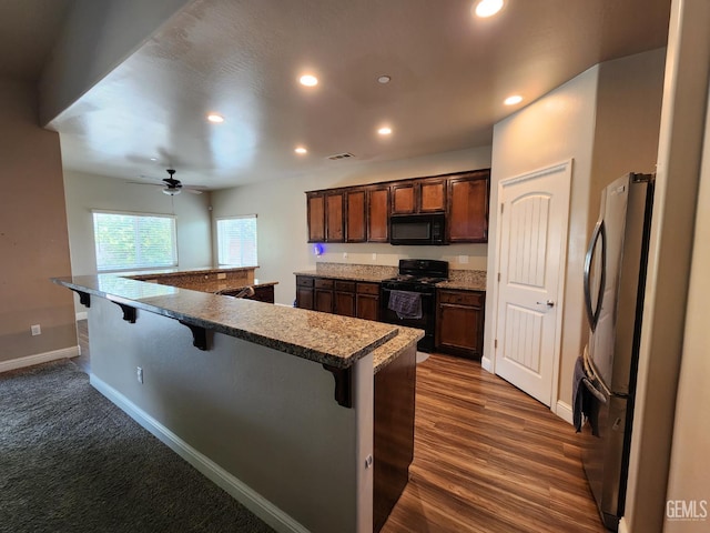 1756 Bautista Ave, Wasco, CA 93280 - kitchen with black appliances, a kitchen breakfast bar, ceiling fan, recessed lighting, and a large island with sink