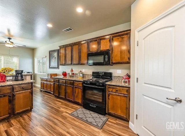 1756 Bautista Ave, Wasco, CA 93280 - kitchen with black appliances, a ceiling fan, wood finished floors, light stone countertops, and recessed lighting