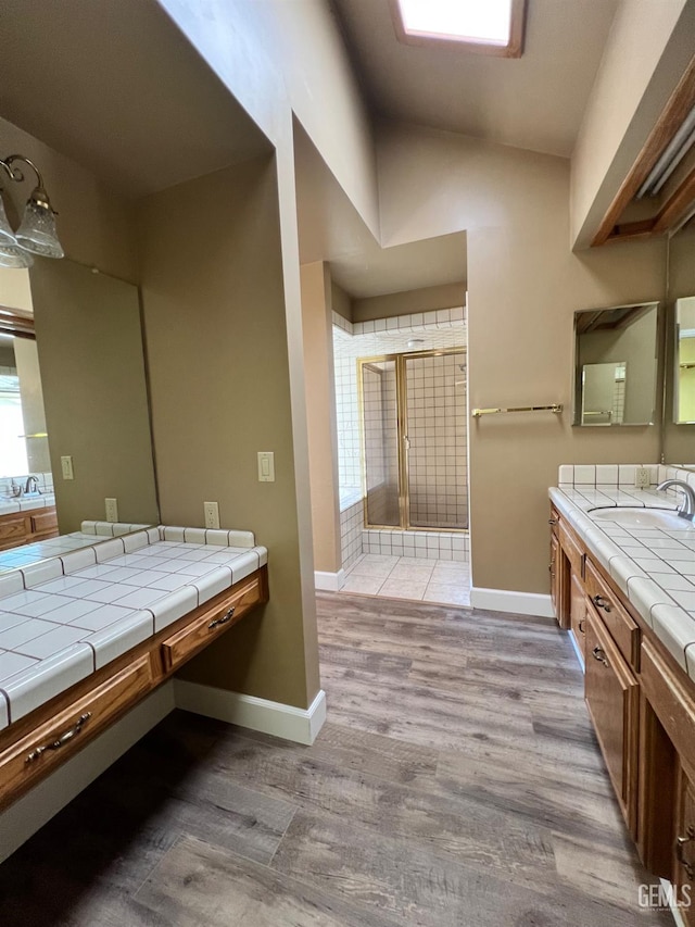 5306 Deville Ct, Bakersfield, CA 93308 - bathroom with a shower stall, vanity, vaulted ceiling, and wood finished floors