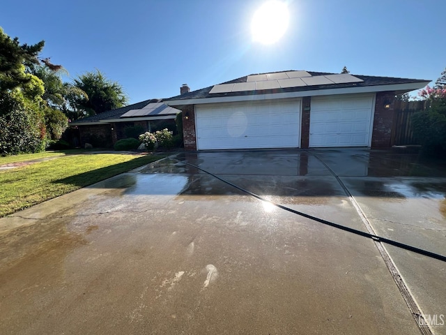 5306 Deville Ct, Bakersfield, CA 93308 - view of property exterior with driveway, solar panels, a garage, and brick siding