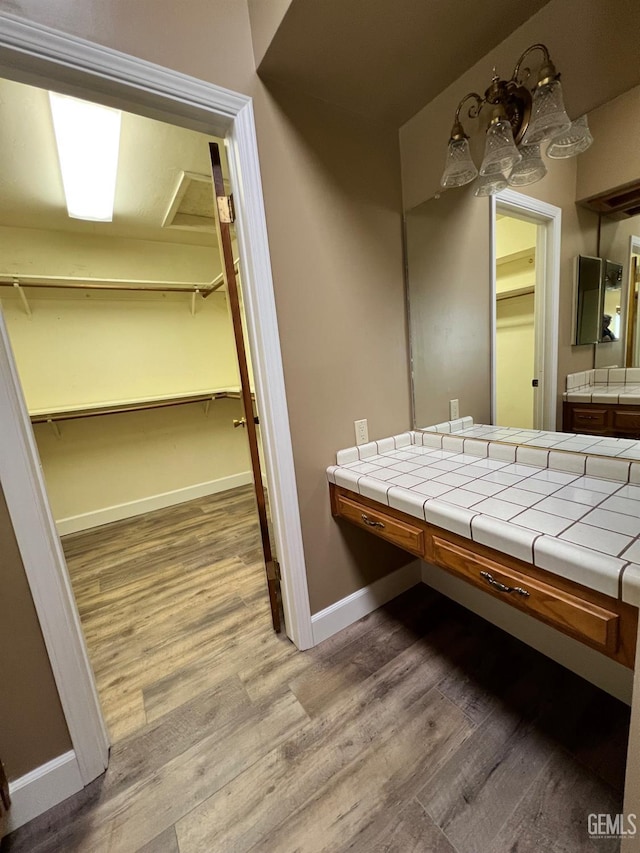 5306 Deville Ct, Bakersfield, CA 93308 - bathroom with wood finished floors, vanity, and a spacious closet