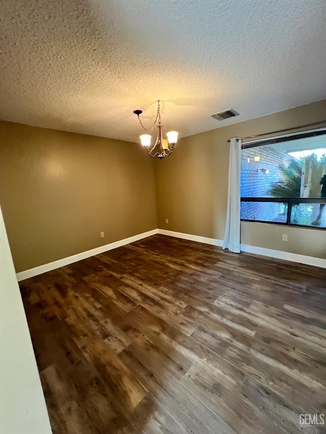 5306 Deville Ct, Bakersfield, CA 93308 - unfurnished room with dark wood finished floors, a chandelier, and a textured ceiling