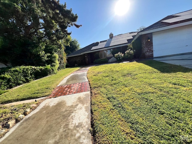 5306 Deville Ct, Bakersfield, CA 93308 - ranch-style house with a front yard, roof mounted solar panels, and a chimney